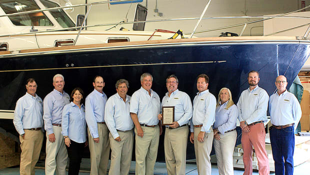 Sabre Yachts vice president of marketing and sales Bentley Collins gives Boston Yacht Sales owner/broker Michael Myers a plaque in recognition of the dealership’s 20th year as a Sabre dealer. From left are Steve Moore; Andrew Savage; Rhonda Corey-Myers; Bruce Taymore; Bob Alliegro; Collins; Myers; Scott Lucas; Joyce Richards; Jonas Krisciunas; and Richard Parker.