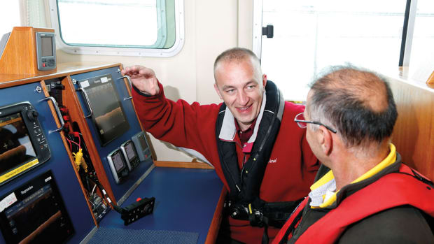 Raymarine product assurance engineer Drew Gorman (left) shows a journalist from Brazil the CHIRP DownVision sonar in one of six testing stations on the company's boat.