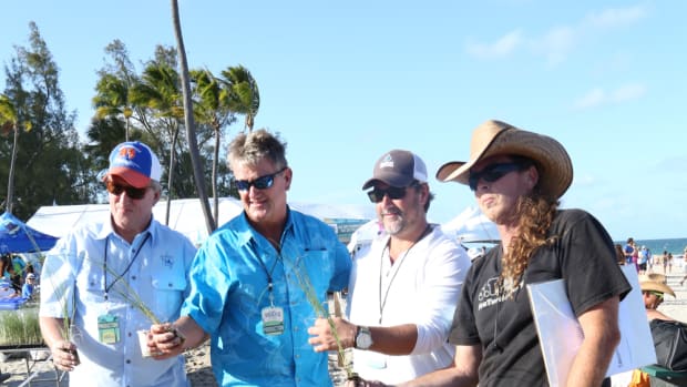 Steve Stock (left), president of the Guy Harvey Ocean Foundation; Guy Harvey; Chris Stacey, founder of the Rock the Ocean Foundation; and Richard WhiteCloud of Sea Turtle Oversight Protection plant sea grass on Fort Lauderdale Beach.