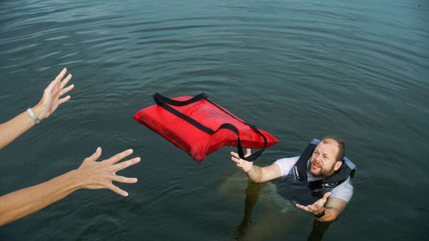 man-in-water-being-thrown-a-floatation-device