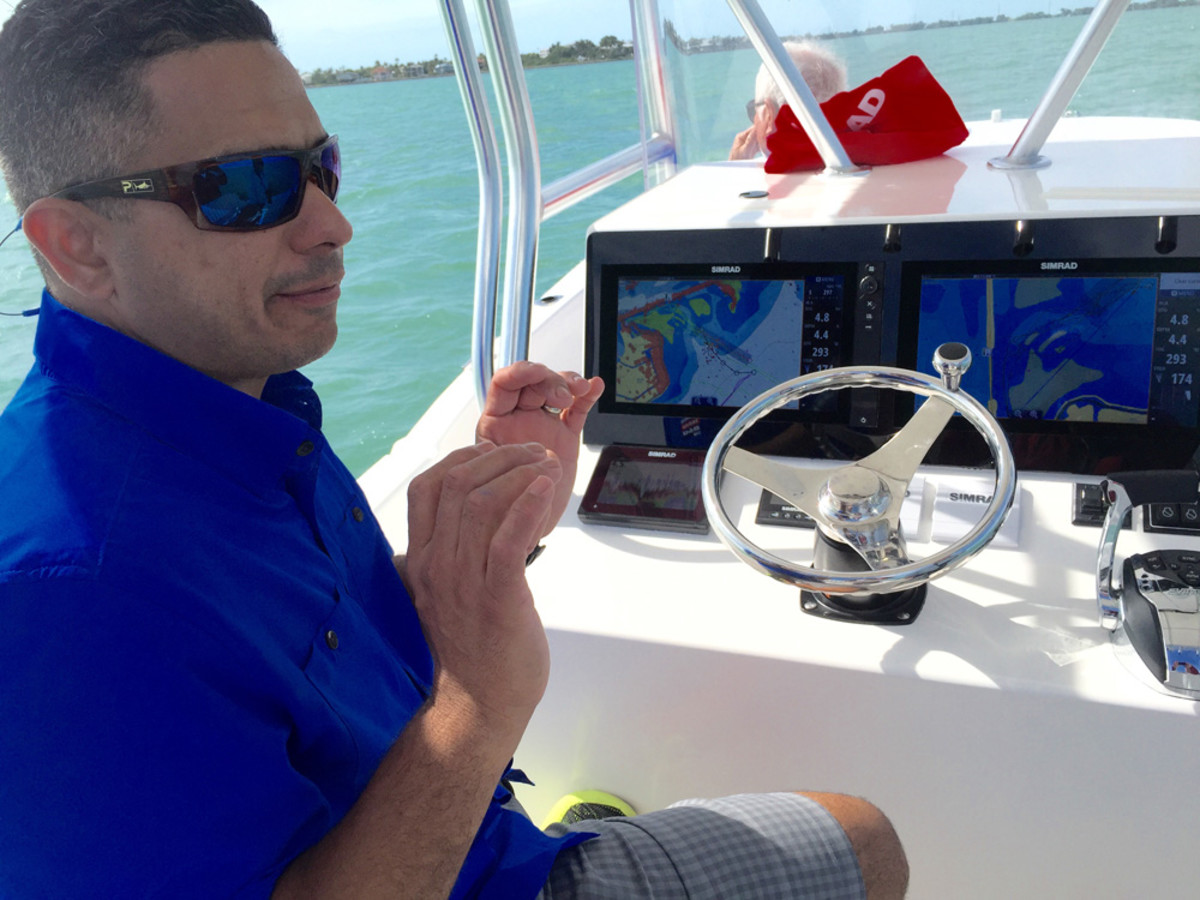 Tito Perez, a key account manager at Simrad, explains the multiple functions of a pair of the NSS Evo2 network navigation systems mounted on a Dusky 278 center console during a Navico press event in the Florida Keys.
