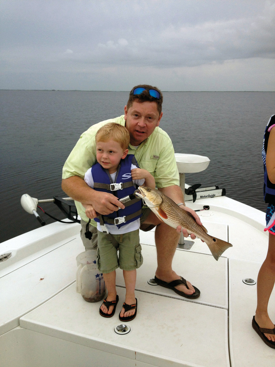 Angers and his son, Graham, with the boy's first redfish.