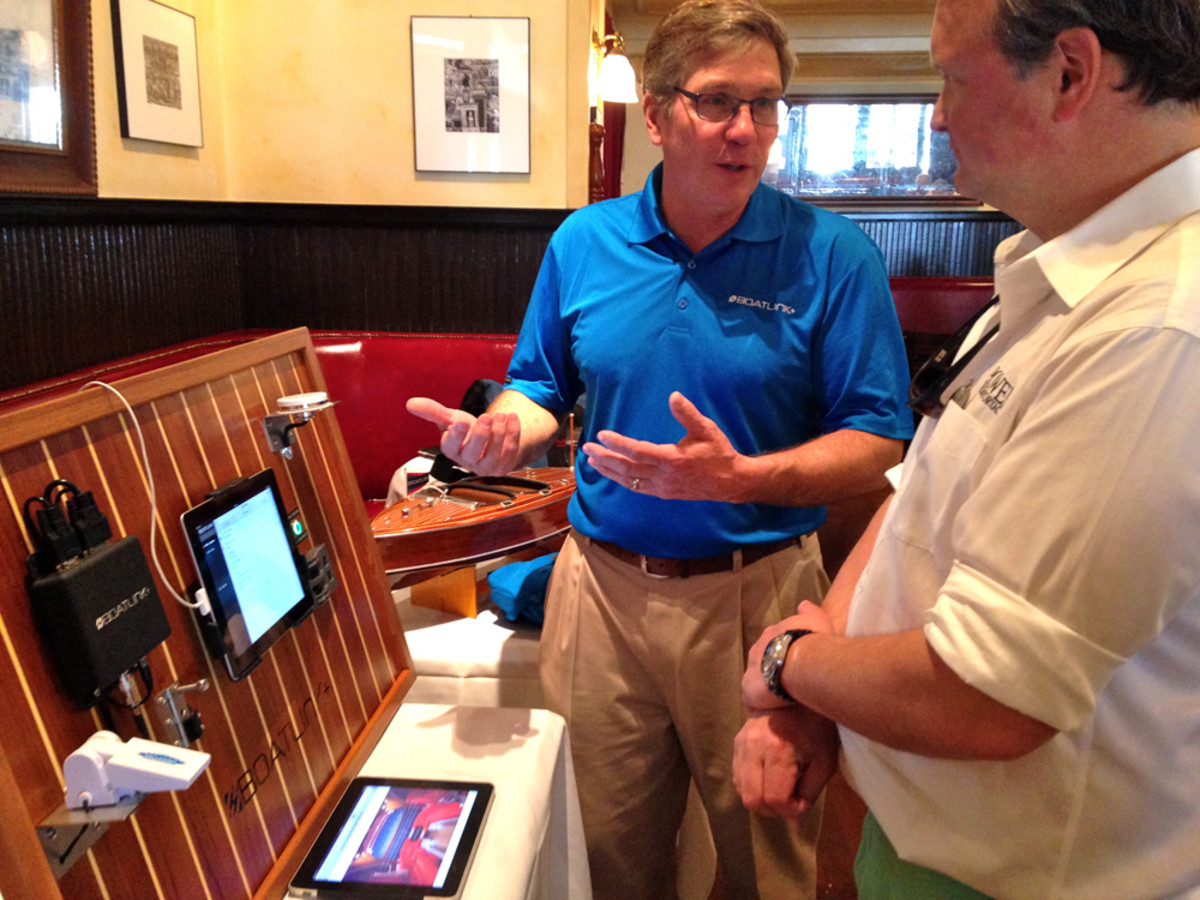 Dave Laska (left), of BoatLink+, explains the boat-monitoring system, which has smartphone alarm capability, to Power & Motoryacht editor-in-chief Jason Wood.