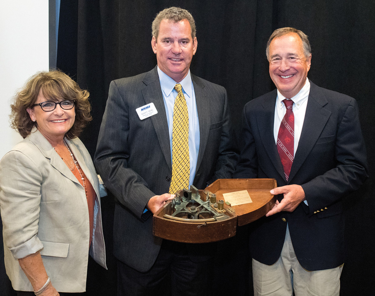 Bass Pro Shops founder Johnny Morris (right) and Maverick Boat Co. founder Scott Deal hold the bronze-framed sextant representing the Eddie Smith Manufacturer of the Year Award. With them is Kris Carroll, president of Grady-White Boats, the company Smith built into a major boatbuilder.