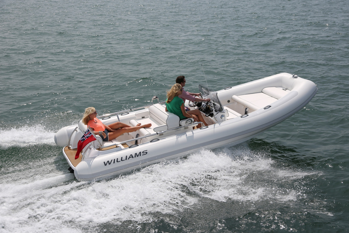 Young people race a boat they designed after taking a course at Williams Performance Tenders.