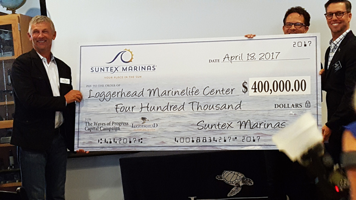 Suntex principal investor Mitchell Jones (left) and Suntex founder and president Johnny Powers (center) present Jack Lighton, president of the Loggerhead Marinelife Center in Juno Beach, Fla., with a donation to its capital fund.