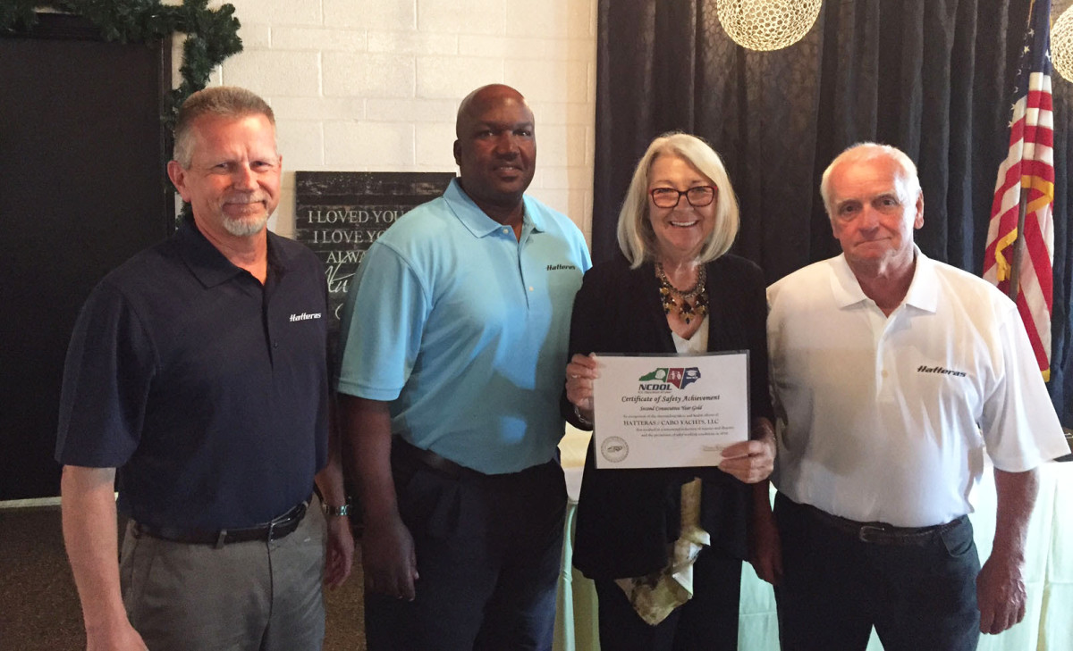 From left: Hatteras Yachts vice president of manufacturing Tim Varner and EH&S specialist Hezekiah Harper, commissioner Cherie Berry, and honoree Tommy Ormond, Hatteras Yachts group leader.