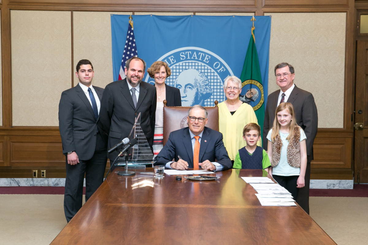 Washington Gov. Jay Inslee (seated, center) signed legislation that could attract more superyacht visitors to the state.