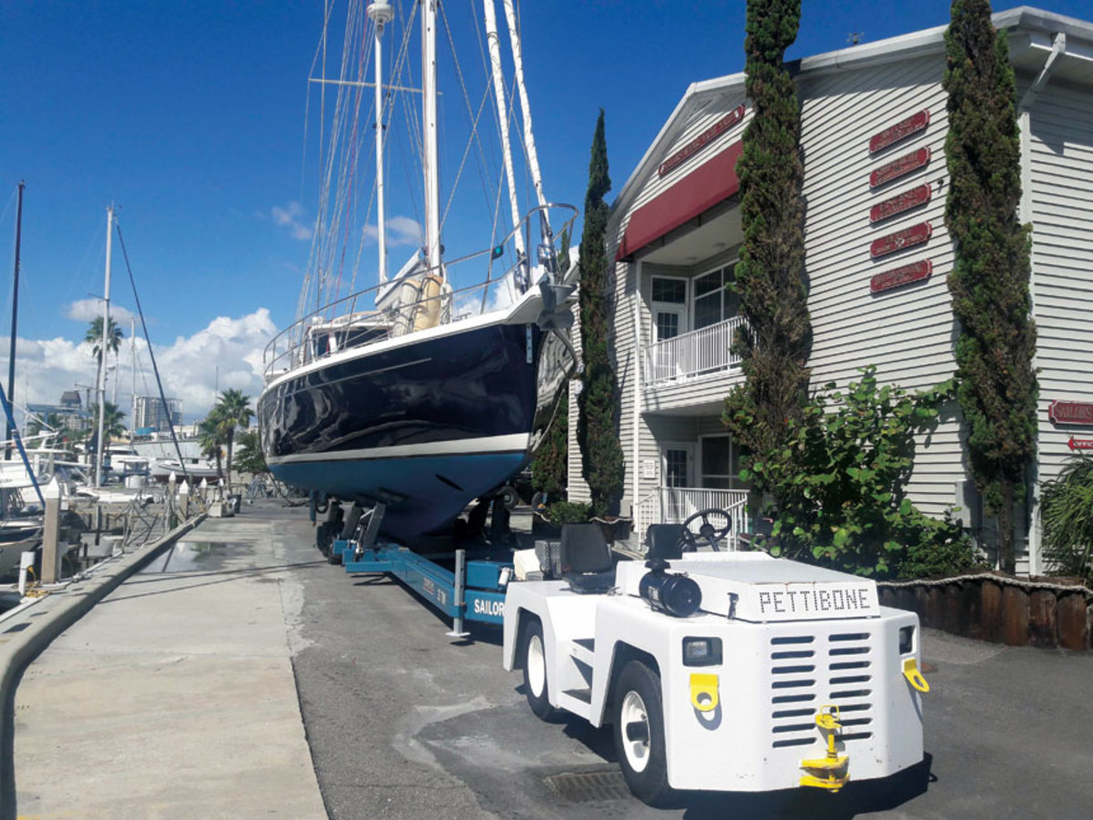 When moving a boat in tight spaces, a hydraulic trailer and a towing tug provide the solution.
