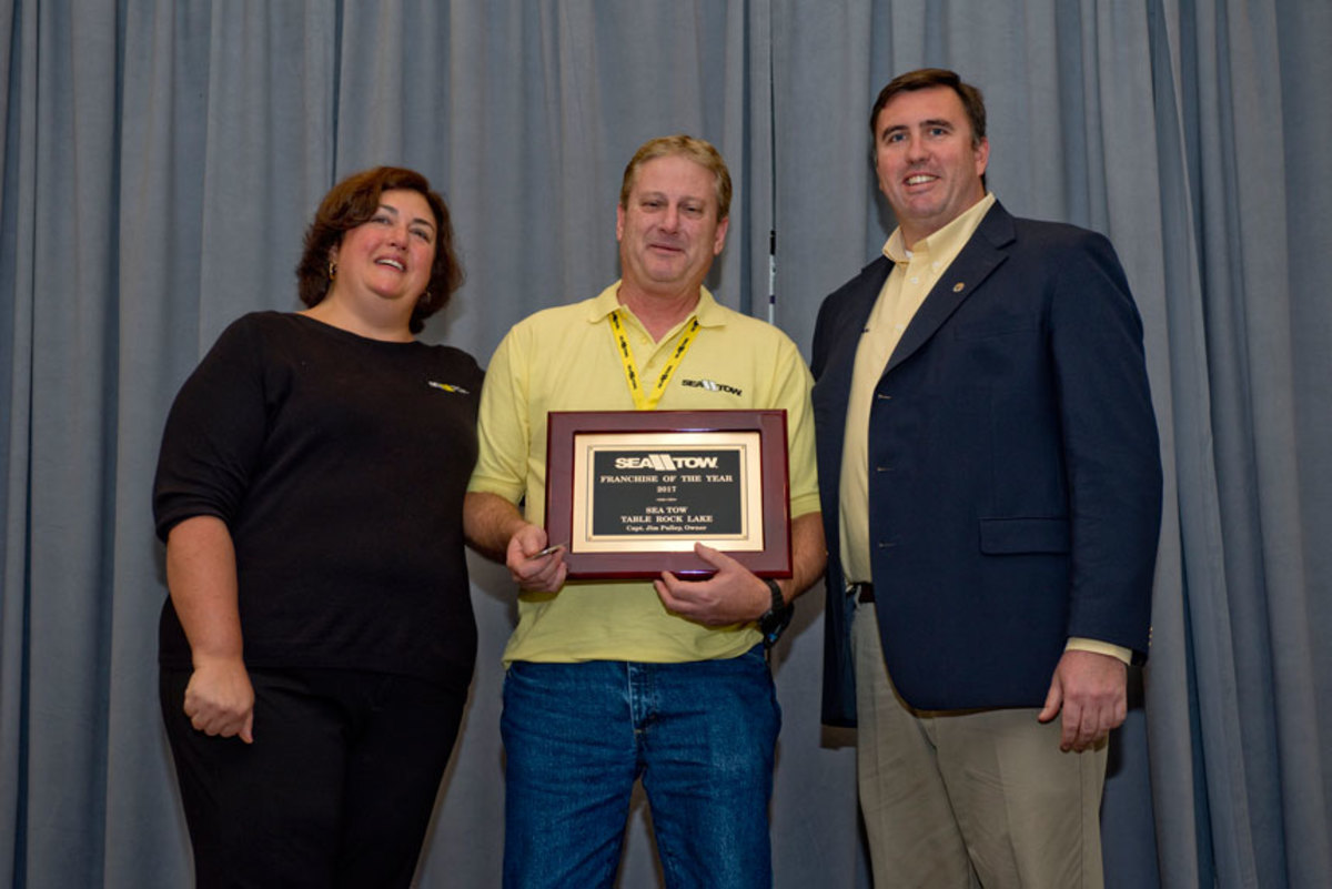 Capt. Jim Pulley (center), owner of Sea Tow Table Rock Lake (Mo.), received the Sea Tow Franchise of the Year Award at the company’s awards banquet last week. Five people were honored. At left is Kristen Frohnhoefer, president of Sea Tow Services International Inc., and at right is the company’s CEO, Capt. Joseph Frohnhoefer III.