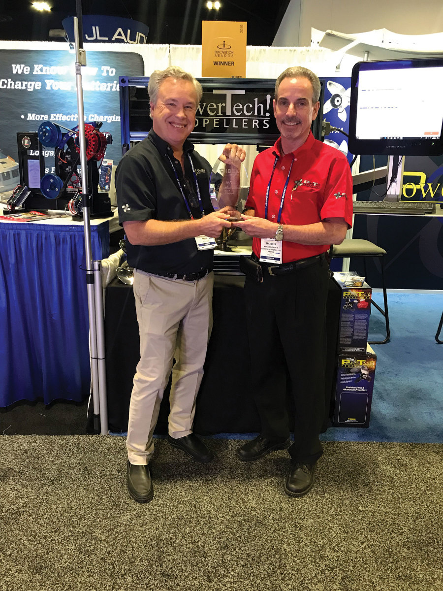 Steve Powers (black shirt) and Marcus Clements with one of the company’s many innovation awards.