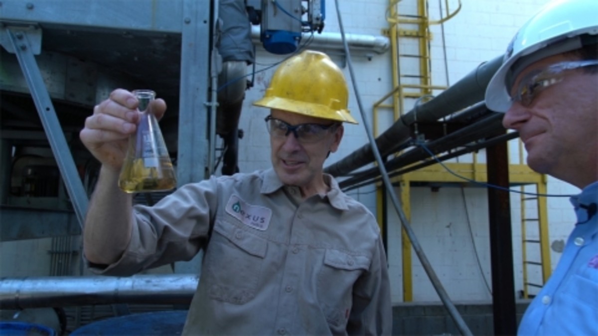 Jeff Gold of Nexus Fuels holds a beaker of recycled liquid from Yamaha shipping plastic that can be repurposed into other materials. (Photo: Business Wire)
